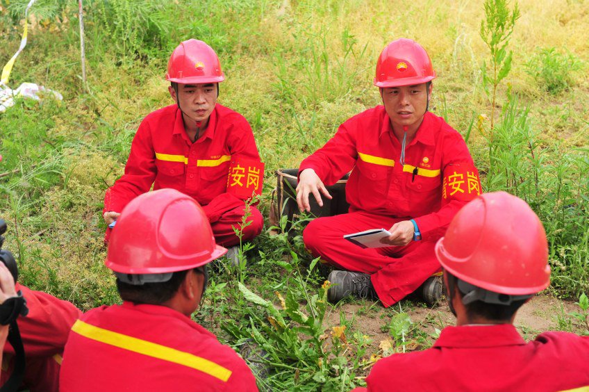 李志恒在测线上调查风险源。李志恒 (右) 组织施工安全班前会。