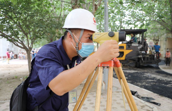 项目现场负责人进行道路高程复核测量项目现场负责人进行道路高程复核测量