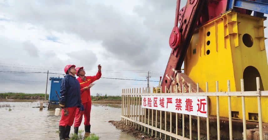 采油一厂作业二区员工雨中巡井保障生产。(张旭)