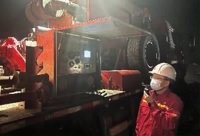 石油工程研究院防砂技术人员夜间在井上监测泵车施工压力变化。 (朱英斌)
